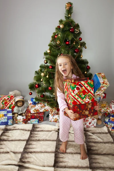 The girl with a gift under the Christmas tree
