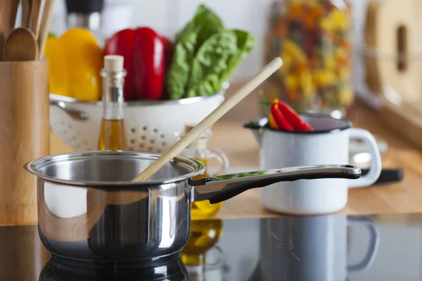 Cooking Pot with Wooden Spoon on Ceramic Hob