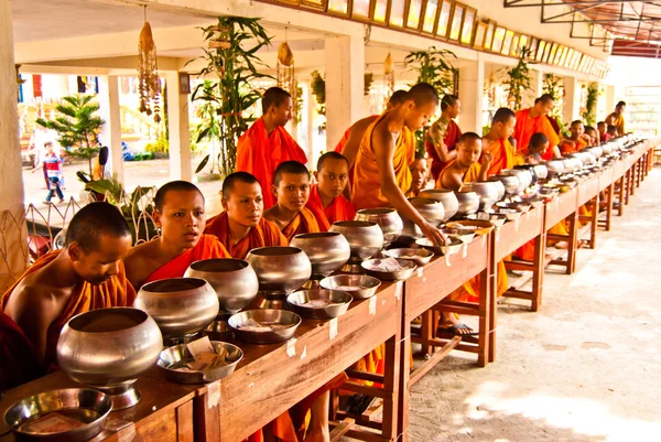 Buddhist monks are in expectation of food and money offerings