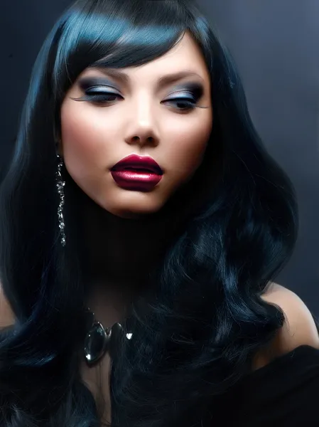 Beautiful Woman With Black Hair and Holiday Professional Makeup