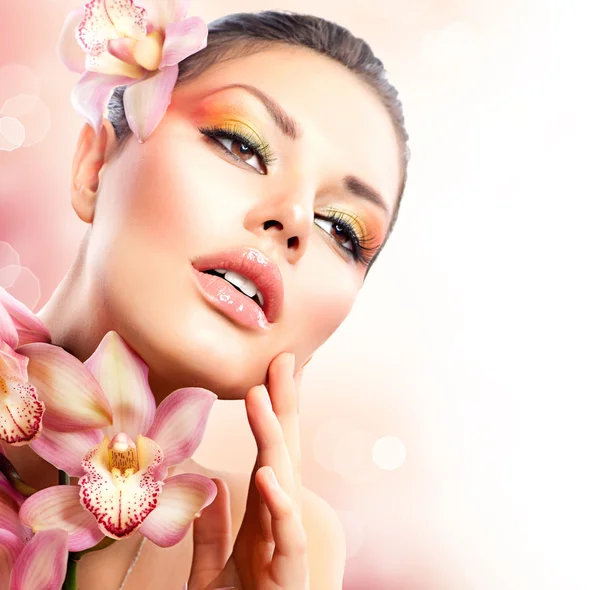 Beautiful Spa Girl With Orchid Flowers Touching her Face