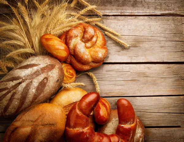 Bakery Bread and Sheaf over Wood Background