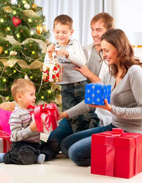 Christmas Family. Children Opening Gifts. Christmas tree