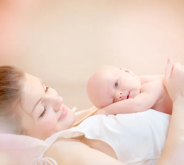 Happy Mother and her Newborn Baby Kissing and hugging