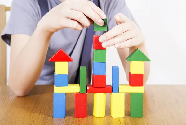 Man builds the house of toy blocks