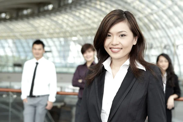 Business woman with colleagues in the background