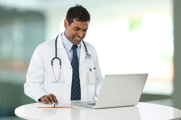 Indian doctor working on his laptop.
