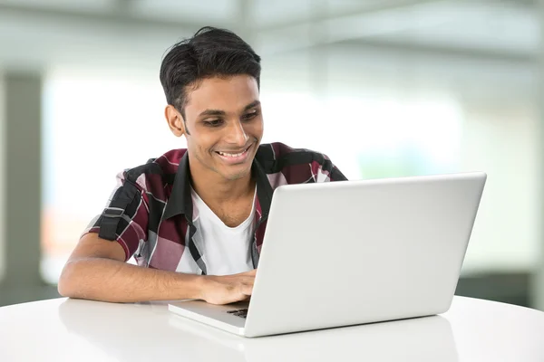 Young Indian man using a laptop