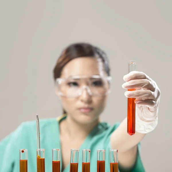 Chinese Woman scientist analyzing a solution.