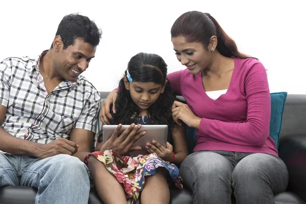 Happy Indian family at home using digital tablet