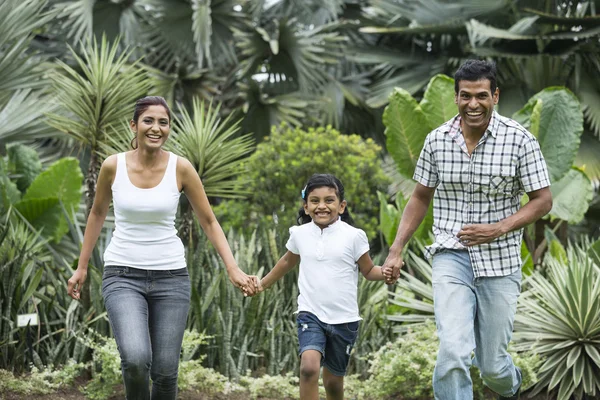 Happy indian family running together outdoors