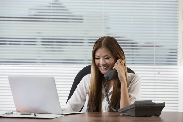 Young Asian woman at work in an office.