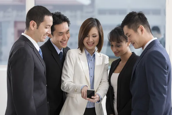 A group of business people looking at a smartphone