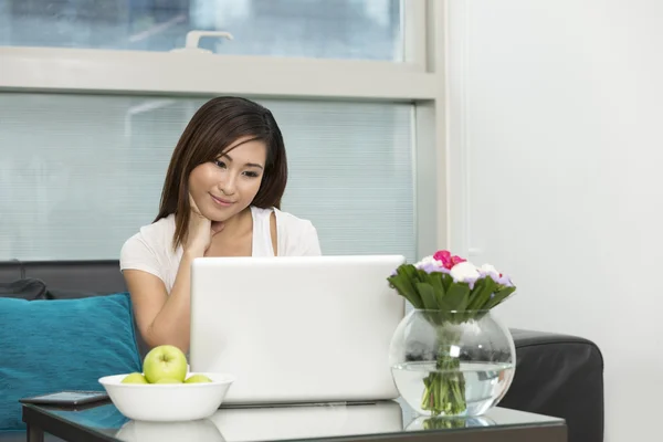 Asian woman at home working on a laptop
