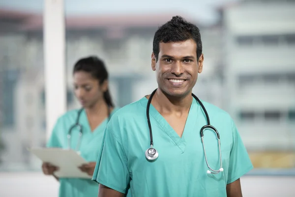 Male Indian doctor standing with his colleague