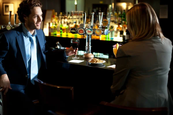 Attractive couple refreshing themselves at the bar