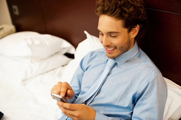 Busy young man surfing menu of his new phone