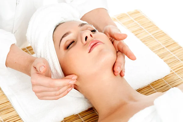 Woman getting facial massage in spa salon