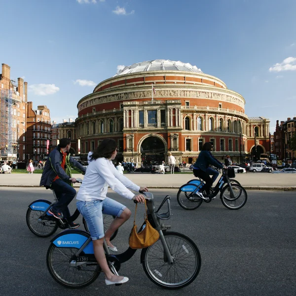 Tourists on rental bike, passing by Royal Albert Hall