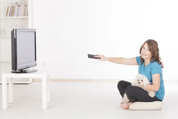 Woman and dog watching TV together