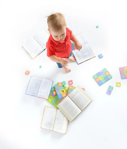 Kid with lot of books and letter puzzles