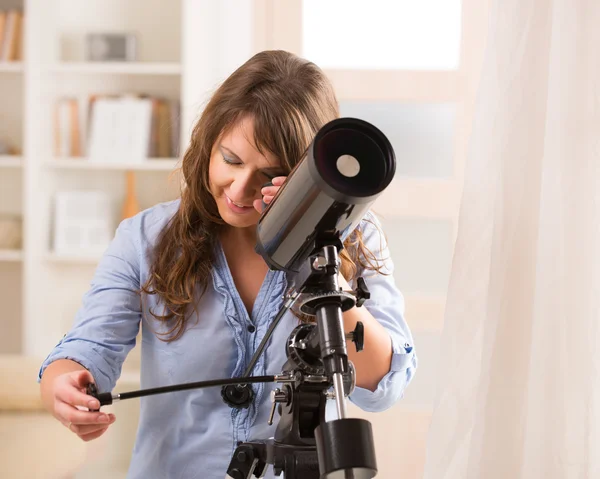 Beautiful woman looking through telescope