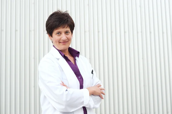 Smiling mature professional woman dressed in labcoat