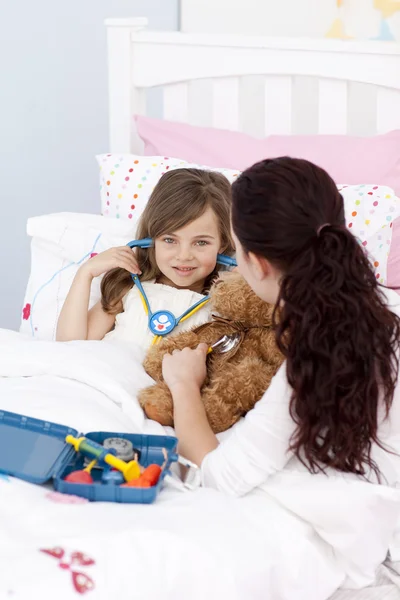 Woman and little girl playing with a stethoscope