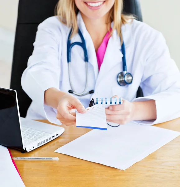 Close-up of a beautiful doctor giving a prescription to a patien