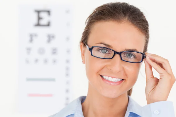 Close up of a good looking brunette eye specialist wearing glass