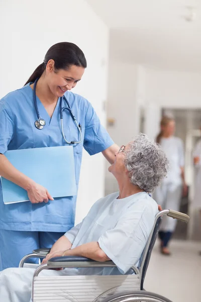 Nurse standing next to a patient in a wheelchair