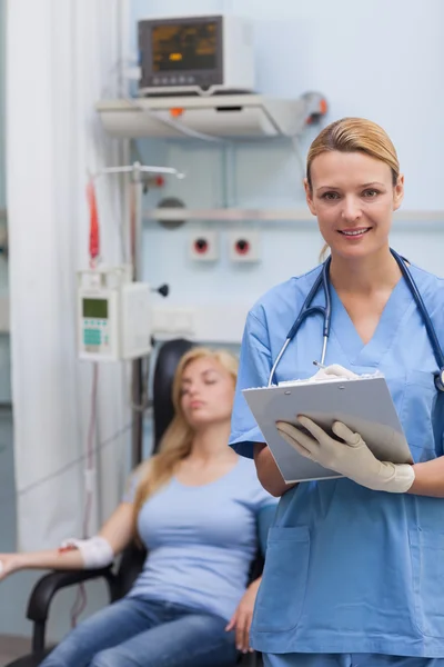 Nurse holding a clipboard while looking at camera