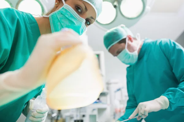 Close up of a nurse holding an anesthesia mask