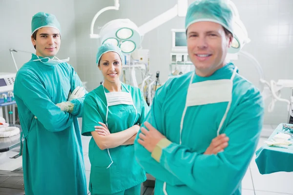 Smiling surgeons looking at camera with crossed arms — Stock Photo #23047314