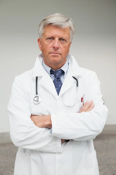 Serious doctor with folded arms
