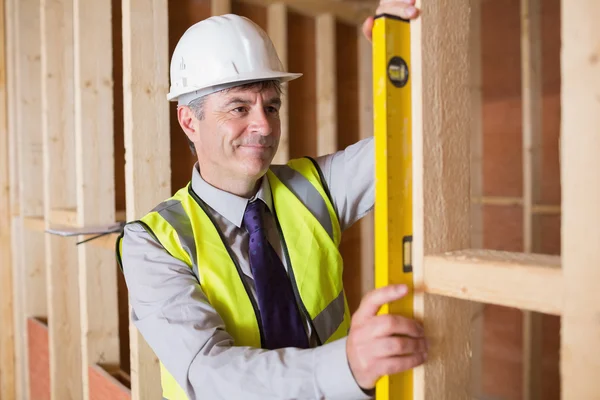 Architect measuring wood frame