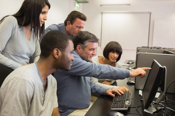 Teacher pointing at computer monitor