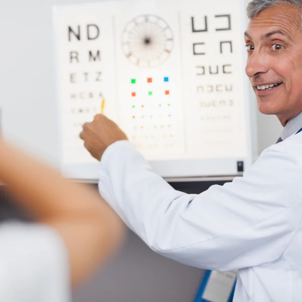 Doctor smiling while doing an eye test on a patient in a hospita