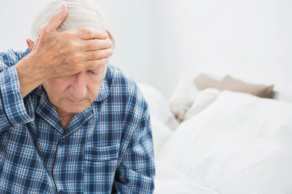 Elderly man suffering on the bed