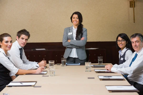 Smiling woman at head of business meeting