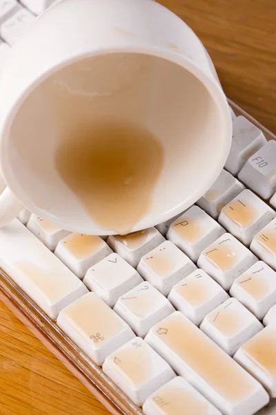 Cup of tea spilled over a keyboard close up