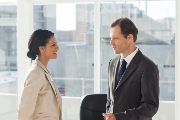 Smiling colleagues speaking together