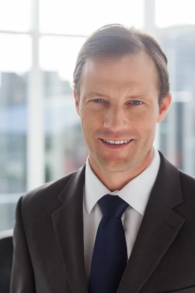 Confident businessman smiling in his office