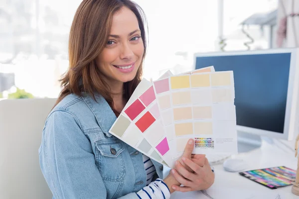 Smiling interior designer holding up colour samples