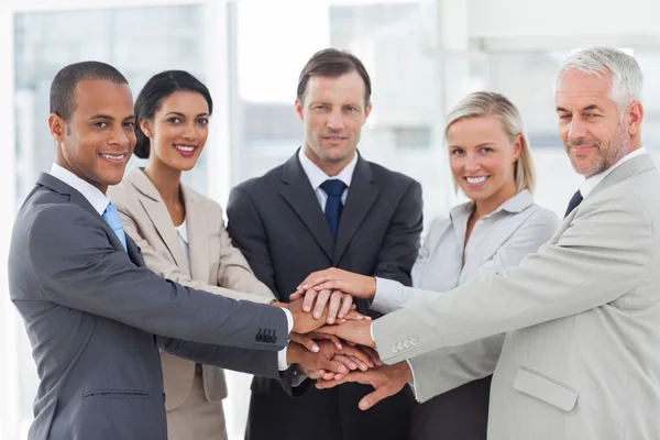 Group of business piling up their hands together