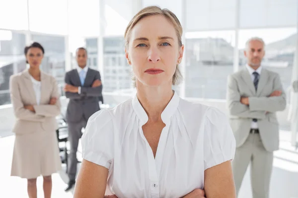 Serious businesswoman standing with arms folded