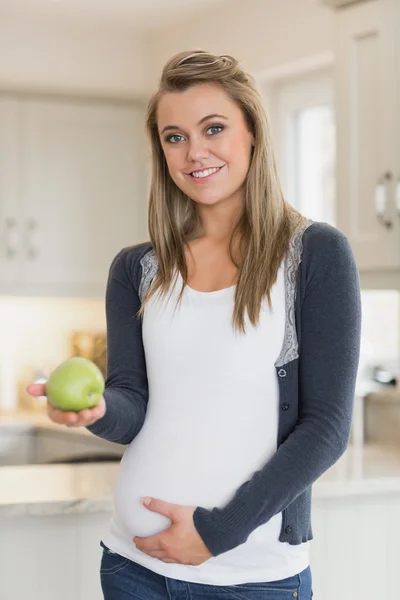Pregnant woman holding an apple in her hands