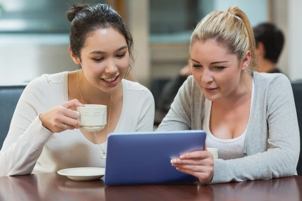 Two students in a coffee shop using a tablet pc