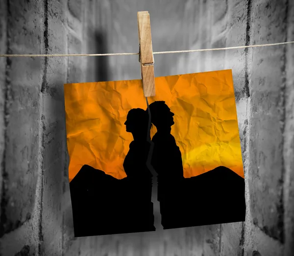 Torn photo of couple hung with a peg on a line