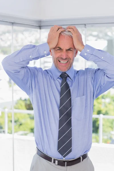 Stressed businessman with hands on his head